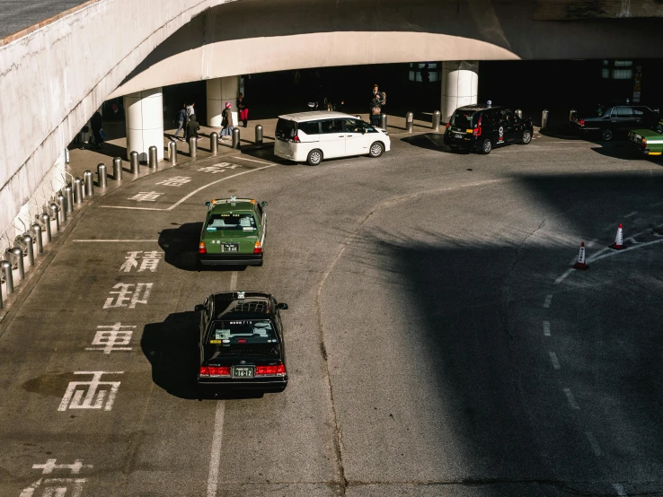 a couple of cars that are sitting in a parking lot, pexels contest winner, kowloon walled city style, overpass, taxi, cars and people