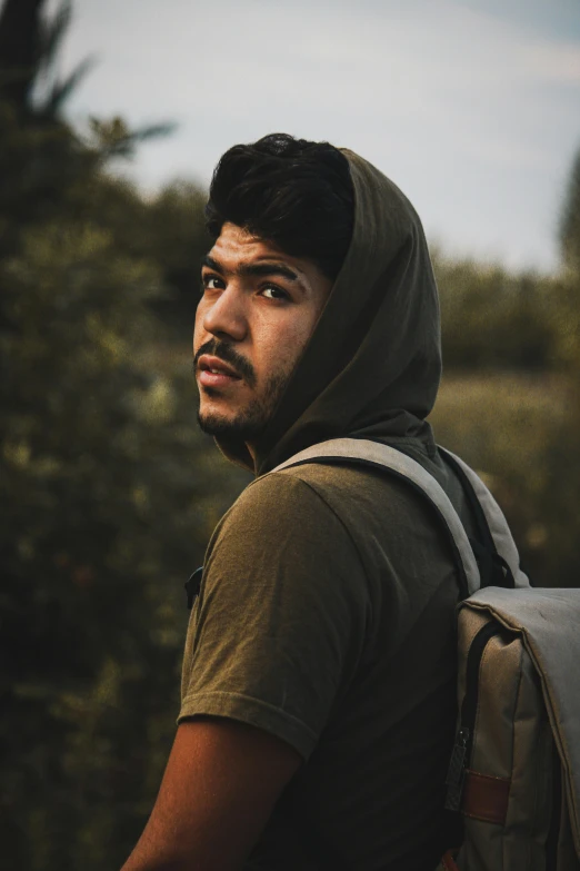 a man with a backpack looking away from the camera, riyahd cassiem, mark edward fischbach, photo taken in 2018, ((portrait))