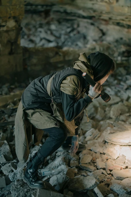 a man kneeling on top of a pile of rubble, inspired by Elsa Bleda, unsplash contest winner, photograph of a techwear woman, hunting, still shot from movie, indoor shot