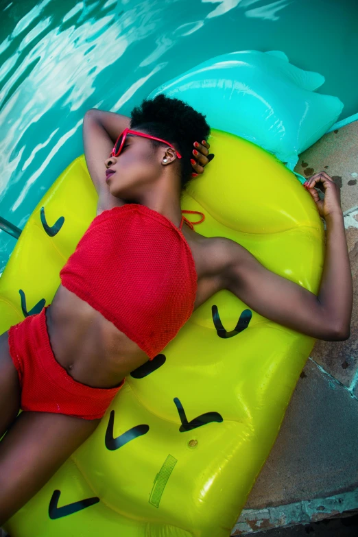 a woman in a red bikini laying on an inflatable banana, by Lily Delissa Joseph, trending on pexels, afrofuturism, portrait willow smith, color blocking, bra and shorts streetwear, profile pic