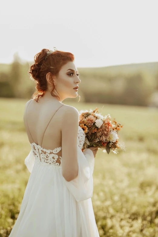 a woman standing in a field holding a bouquet, pexels contest winner, renaissance, beautiful redhead woman, in wedding dresses, looking off into the sunset, playful updo