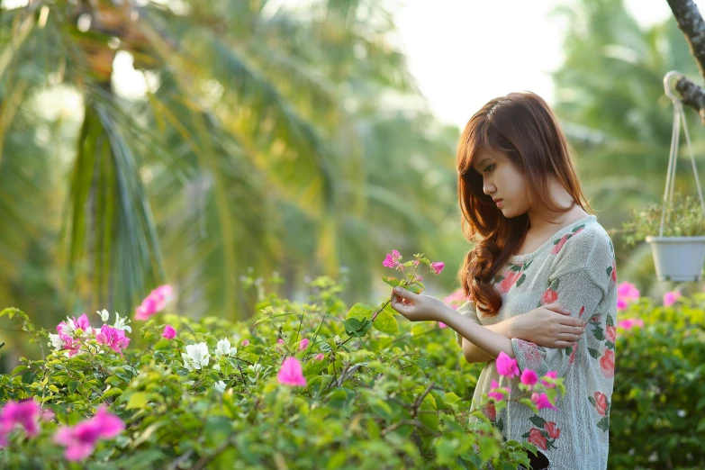 a woman looking at flowers in a garden, a picture, vietnamese woman, paradise garden massage, gentle lighting, avatar image