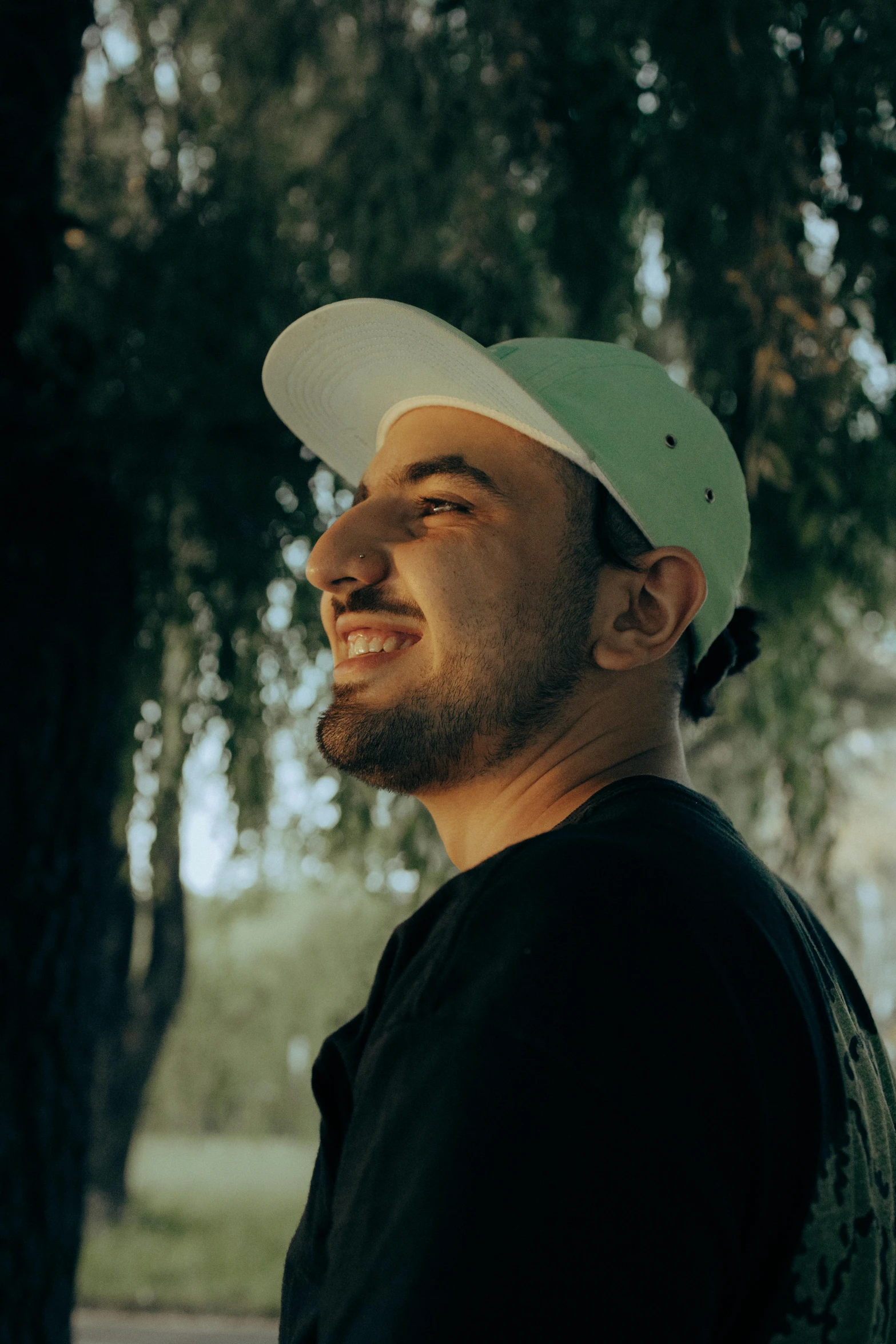 a man standing next to a tree with a frisbee in his hand, a picture, inspired by Ahmed Yacoubi, pexels contest winner, headshot profile picture, wearing a baseball cap backwards, smileing nright, discord profile picture