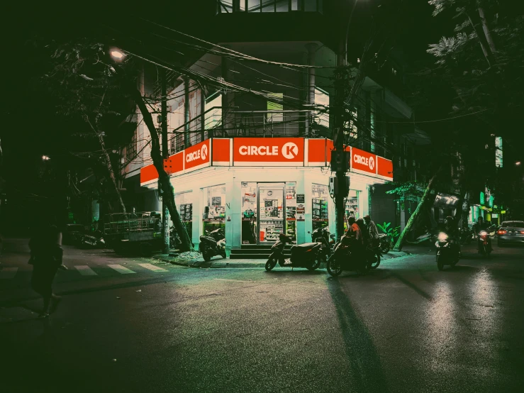 a couple of motorcycles that are parked in front of a building, an album cover, pexels contest winner, concentric circles, convenience store, people at night, vietnam