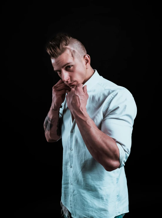 a man in a white shirt on a black background, an album cover, inspired by Adrian Zingg, pexels contest winner, undercut haircut, muscular! white, extremely emotional, a blond