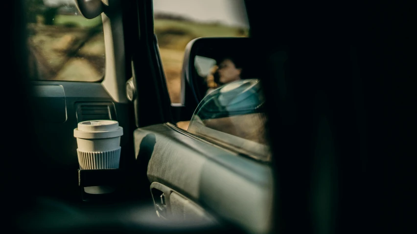 a coffee cup sitting in the passenger seat of a car, by Daniel Seghers, trending on unsplash, photorealism, todd hido photography, off-roading, avatar image