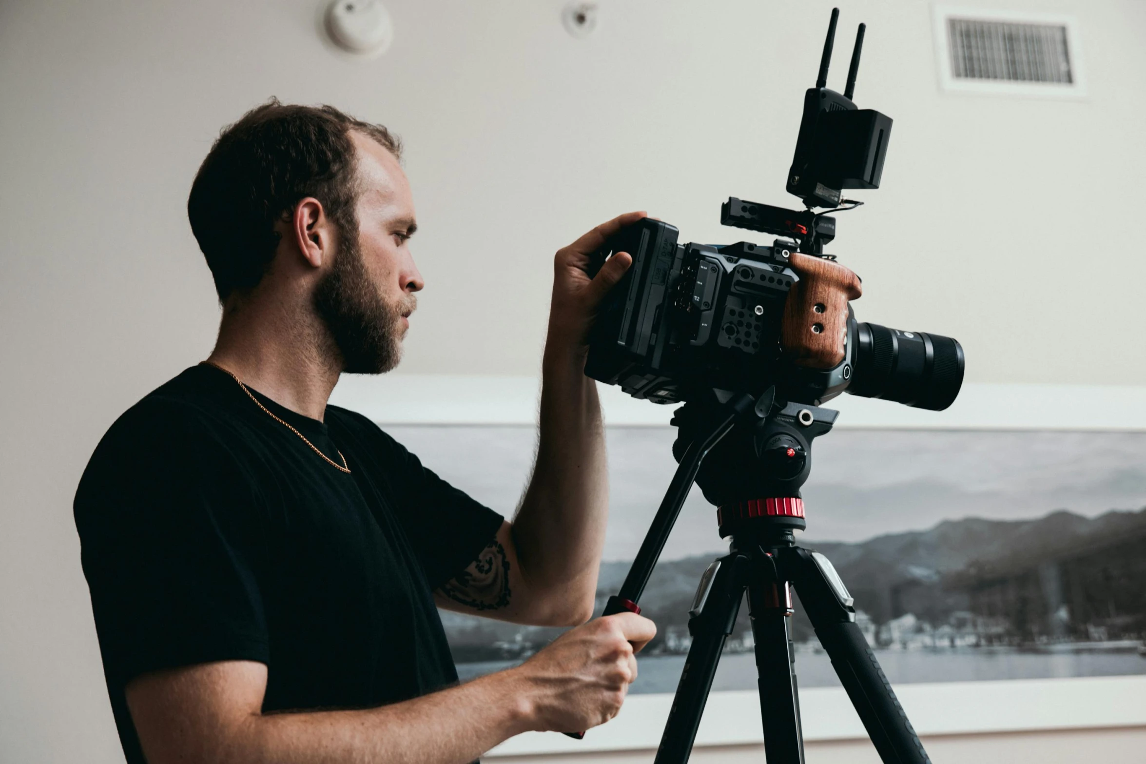 a man standing next to a camera on a tripod, pexels contest winner, video art, anamorphic film, mid-shot of a hunky, professional profile picture, cinestill colour cinematography