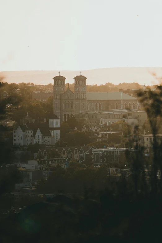 a view of a city from the top of a hill, cathedrals and abbeys, soft light from the side, golden hour photograph, grey