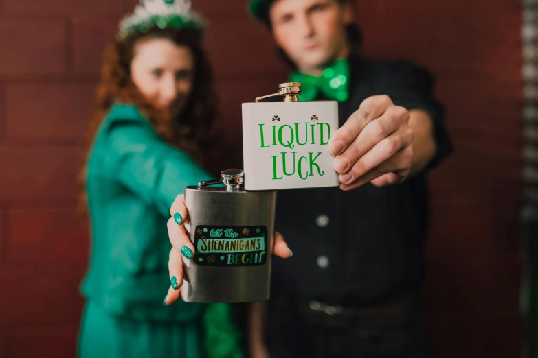 a man and a woman standing next to each other, a photo, by Nicolette Macnamara, trending on unsplash, holding flask in hand, green letters, beer, organic liquid metal