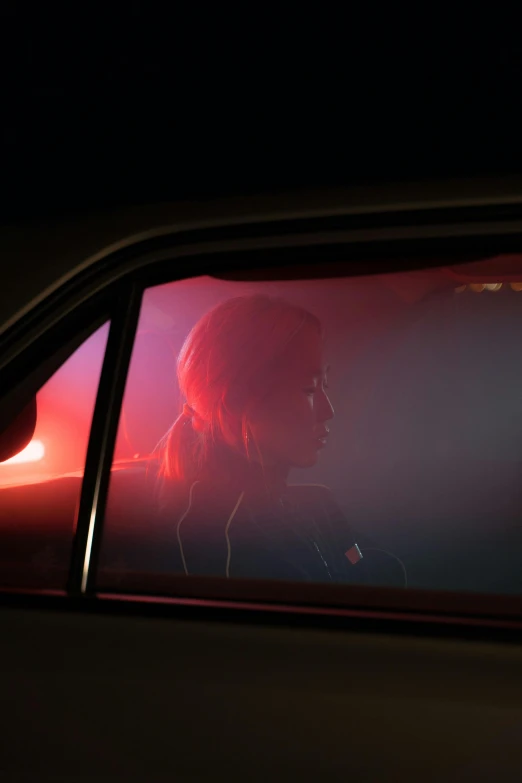 a woman sitting in the passenger seat of a car, an album cover, inspired by roger deakins, photorealism, redhead female cyberpunk, neon fog, photographed for reuters, sideview