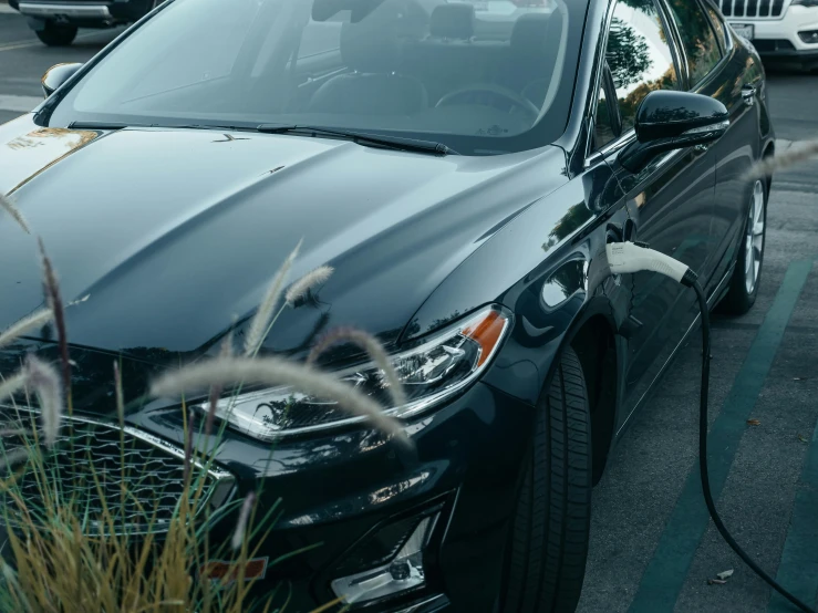 a car is plugged into a charging station, unsplash, photorealism, ford fusion, low quality photo, black car, cinematic shot ar 9:16 -n 6 -g