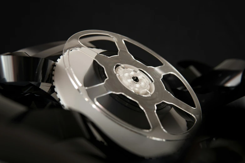 a close up of a watch on a black surface, inspired by Josef Čapek, video art, film strip reel showing 9 frames, detailed alloy wheels, award-winning cinema, 7000mm film