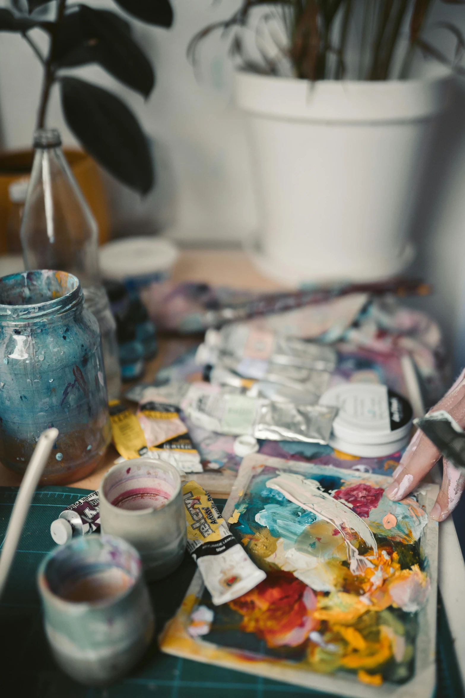 a close up of a person painting on a table, trending on unsplash, process art, can of paint, inside a cluttered art studio, trending photo, liquid oilpaint