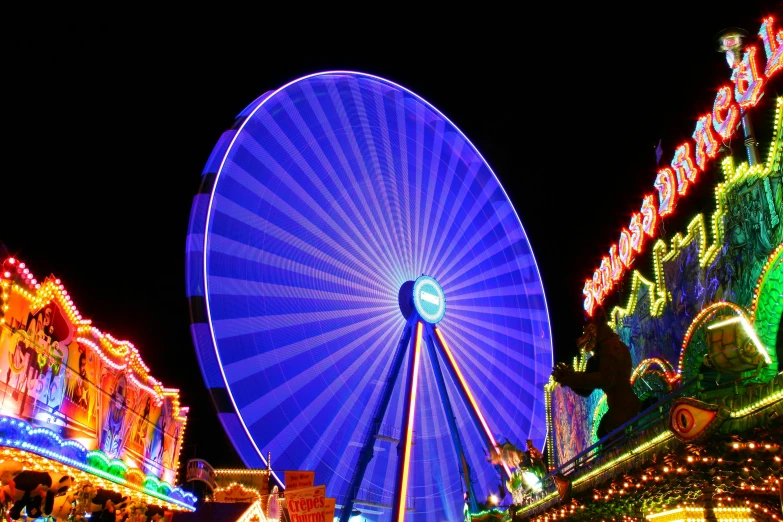 a ferris wheel is lit up at night, by Matthias Weischer, avatar image