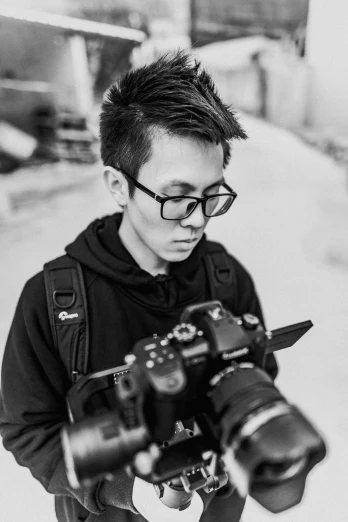 a black and white photo of a man holding a camera, inspired by Feng Zhu, discord profile picture, low quality, mateus 9 5, [ realistic photography ]