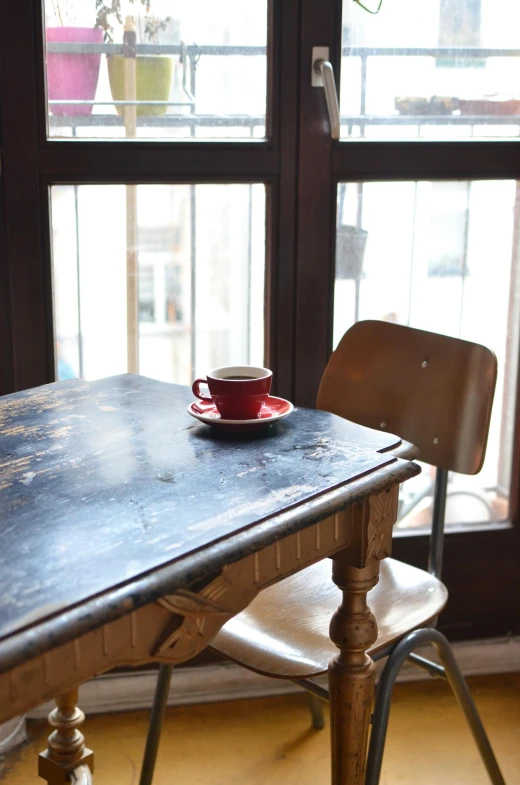 a table with a cup of coffee on top of it, renaissance, small hipster coffee shop, indigo and venetian red, multiple stories, worn