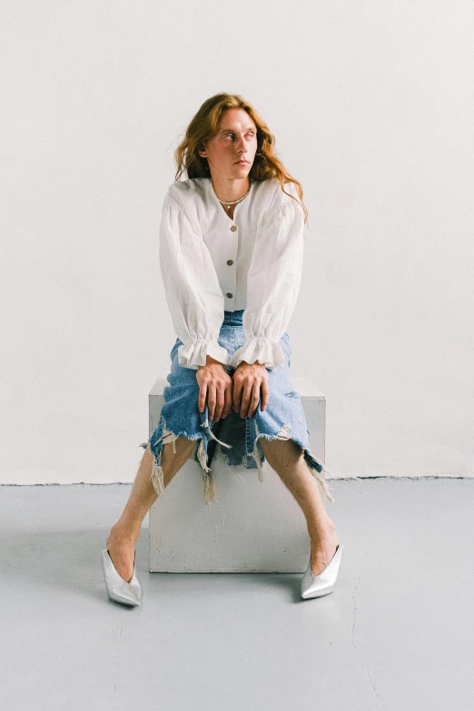 a woman sitting on top of a white box, an album cover, inspired by Anita Malfatti, trending on unsplash, renaissance, baggy jeans, britt marling style 3/4, white skirt, with shoulder pads