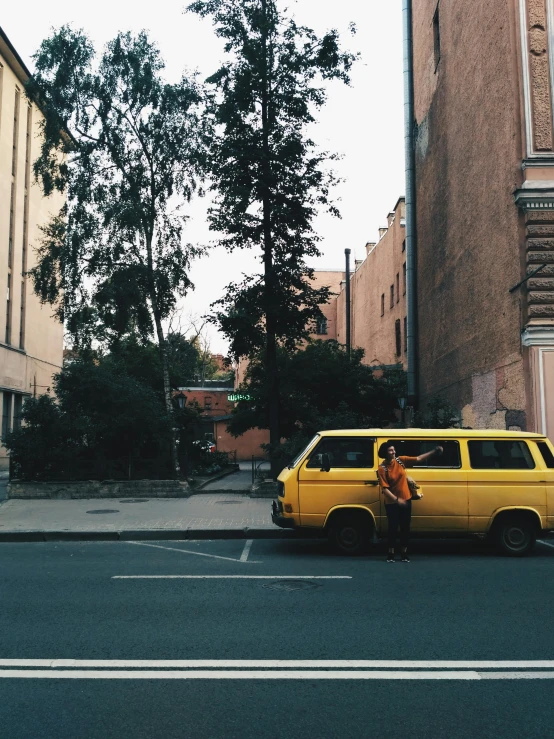 a yellow van parked on the side of a street, a photo, pexels contest winner, neo kyiv, posing for a picture, iphone photo, 90s photo