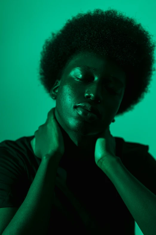 a woman standing in front of a green background, trending on unsplash, black arts movement, he has a glow coming from him, black teenage boy, lowkey lighting, monochromatic green