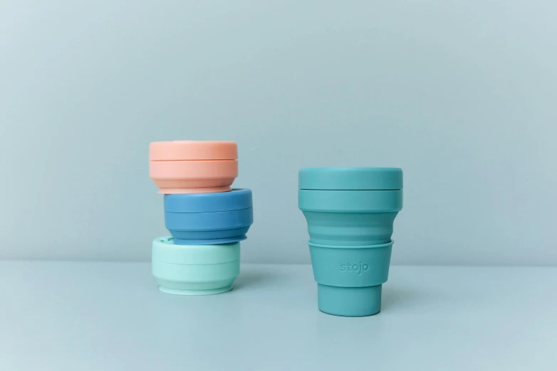 a couple of cups sitting on top of each other, silicone skin, sherbert sky, medium - shot, folded