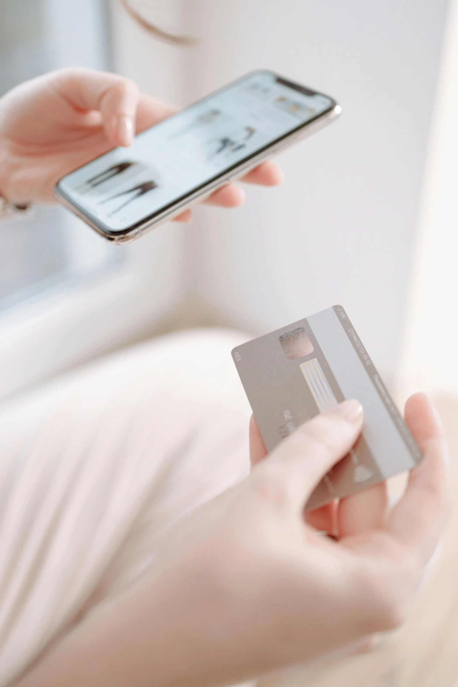 a woman holding a credit card and a smart phone, by Adam Marczyński, trending on pexels, figuration libre, detailed product image, grey metal body, soft shade, digital image