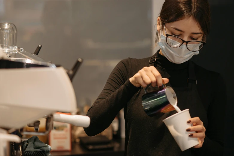 a woman in a face mask pours coffee into a cup, by Jang Seung-eop, pexels contest winner, aussie baristas, avatar image, maintenance, thumbnail