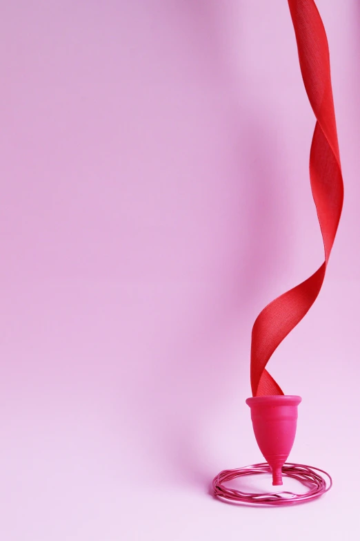 a pink vase with a red ribbon around it, a picture, by Paul Bird, trending on pexels, conceptual art, cone, contracept, lesbians, balloon