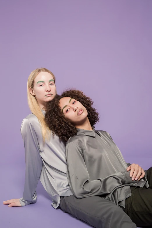 two women sitting next to each other on a purple background, trending on pexels, mannerism, grey robe, ashteroth, portrait image, iridescent