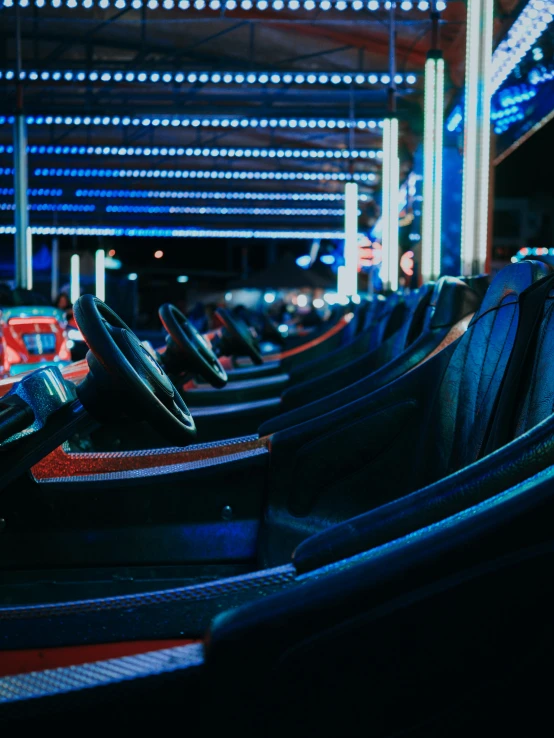 a row of bumper cars sitting next to each other, blue and red lights, profile image, inside a casino, f/1.4