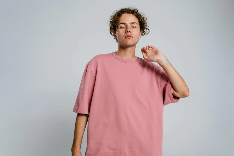 a man with curly hair wearing a pink t - shirt, trending on pexels, oversized, federation clothing, 8ft tall, muted colour