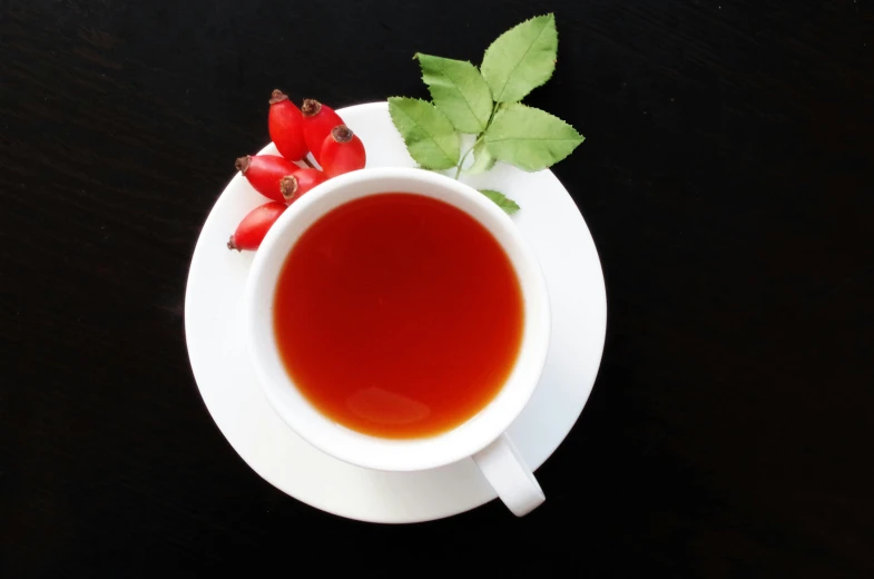 a cup of tea sitting on top of a saucer, pomegranade, basil gogos, natural point rose', maple syrup fluid