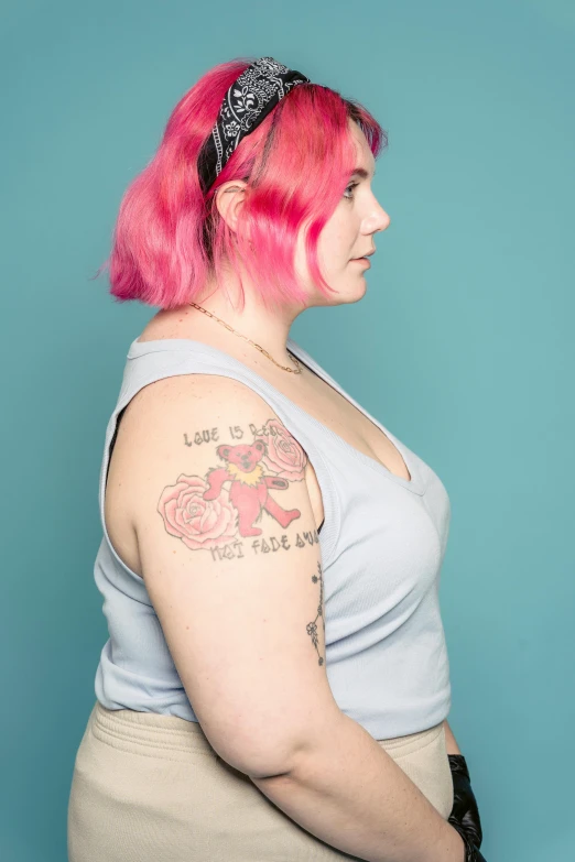 a woman with pink hair and a tattoo on her arm, a tattoo, inspired by Jessie Alexandra Dick, feminist art, overweight, photograph taken in 2 0 2 0, shoulder - length, single flat colour