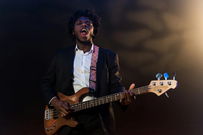 a man in a suit playing a bass guitar, by Stokely Webster, pexels contest winner, black man with afro hair, brown skin man with a giant grin, lit up, concerned