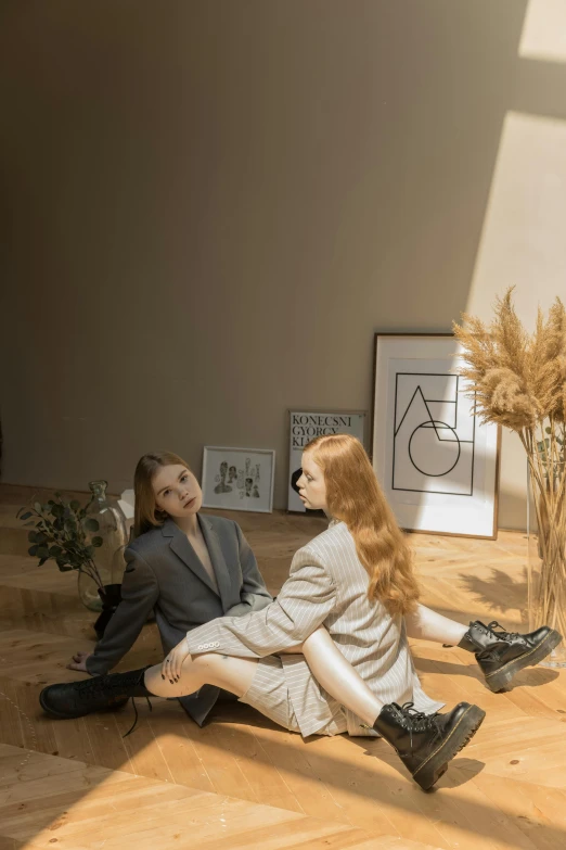 a couple of people sitting on top of a wooden floor, a picture, inspired by Elsa Bleda, trending on pexels, aestheticism, on a mannequin. high quality, cai xukun, mary jane ansell, portrait of two people