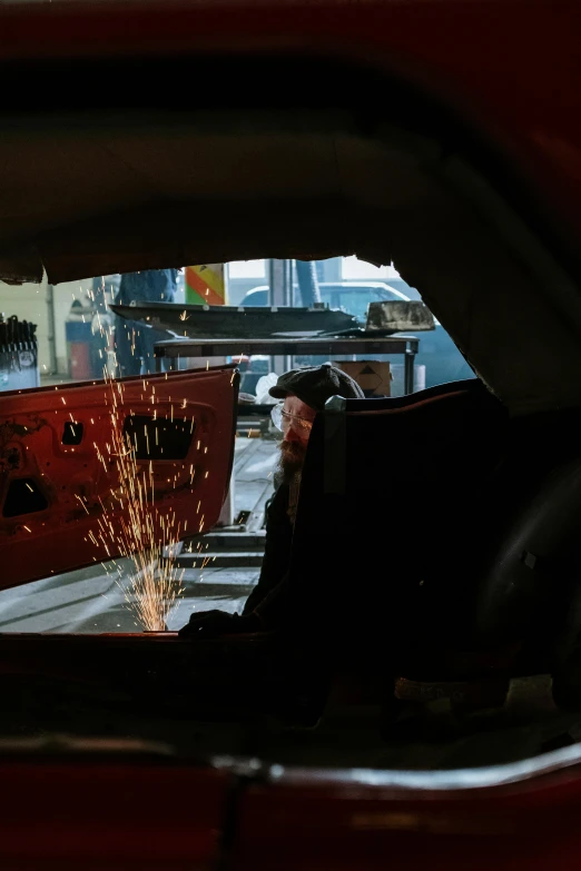 a man that is standing in the back of a car, pexels contest winner, auto-destructive art, welding torches for arms, cavernous interior wide shot, profile picture, photographed for reuters