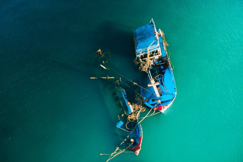 a couple of boats that are in the water, by Sebastian Spreng, unsplash contest winner, hurufiyya, vietnam, bottom angle, cerulean, maintenance photo