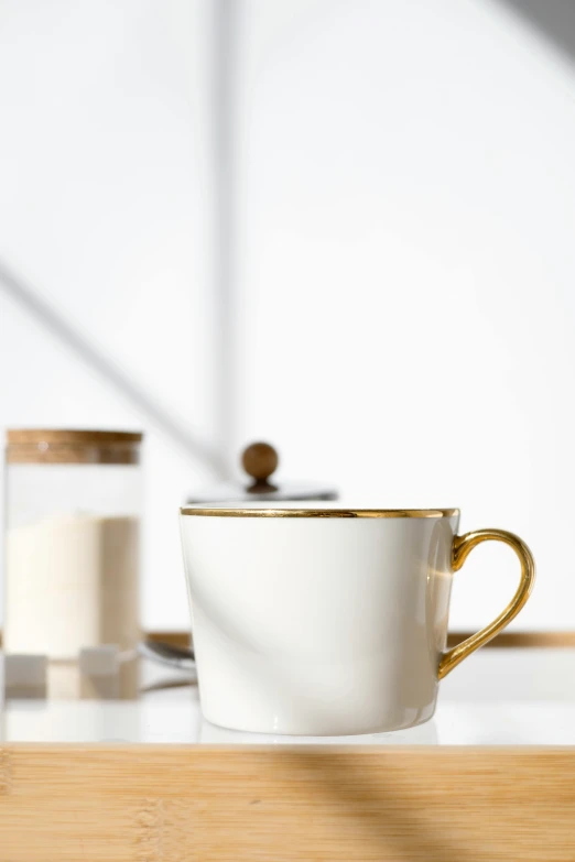 a coffee cup sitting on top of a wooden table, a still life, inspired by Kanō Shōsenin, renaissance, white and gold color scheme, detailed product image, detail shot, beige mist