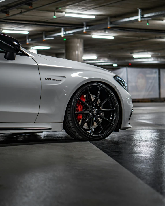 a white car parked in a parking garage, inspired by An Gyeon, black rims, silver white red details, thumbnail, profile image