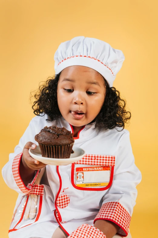 a little girl holding a plate with a cupcake on it, pexels contest winner, dressed as a pastry chef, brown, gif, 1x