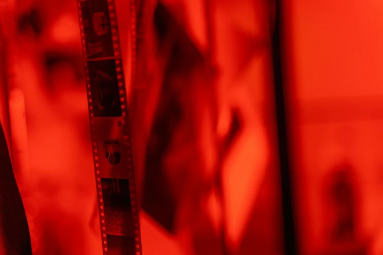 a pair of scissors sitting on top of a table, a picture, inspired by Germaine Krull, pexels, video art, red light, photo of the cinema screen, 3 5 mm close up, orange and red lighting
