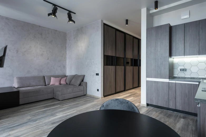 a living room filled with furniture next to a kitchen, by Adam Marczyński, black and grey, units, ultra - quality, small bedroom