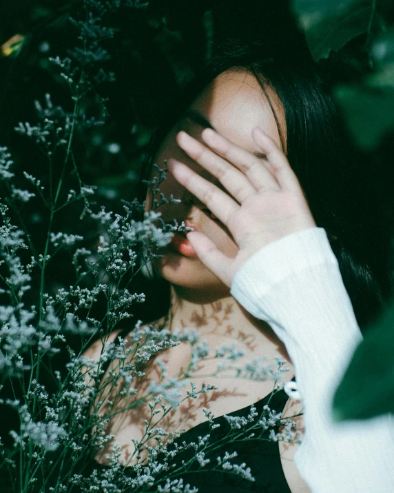 a woman covering her face with her hands, inspired by Elsa Bleda, aestheticism, lush foliage, snapchat photo, asian women, trending photo