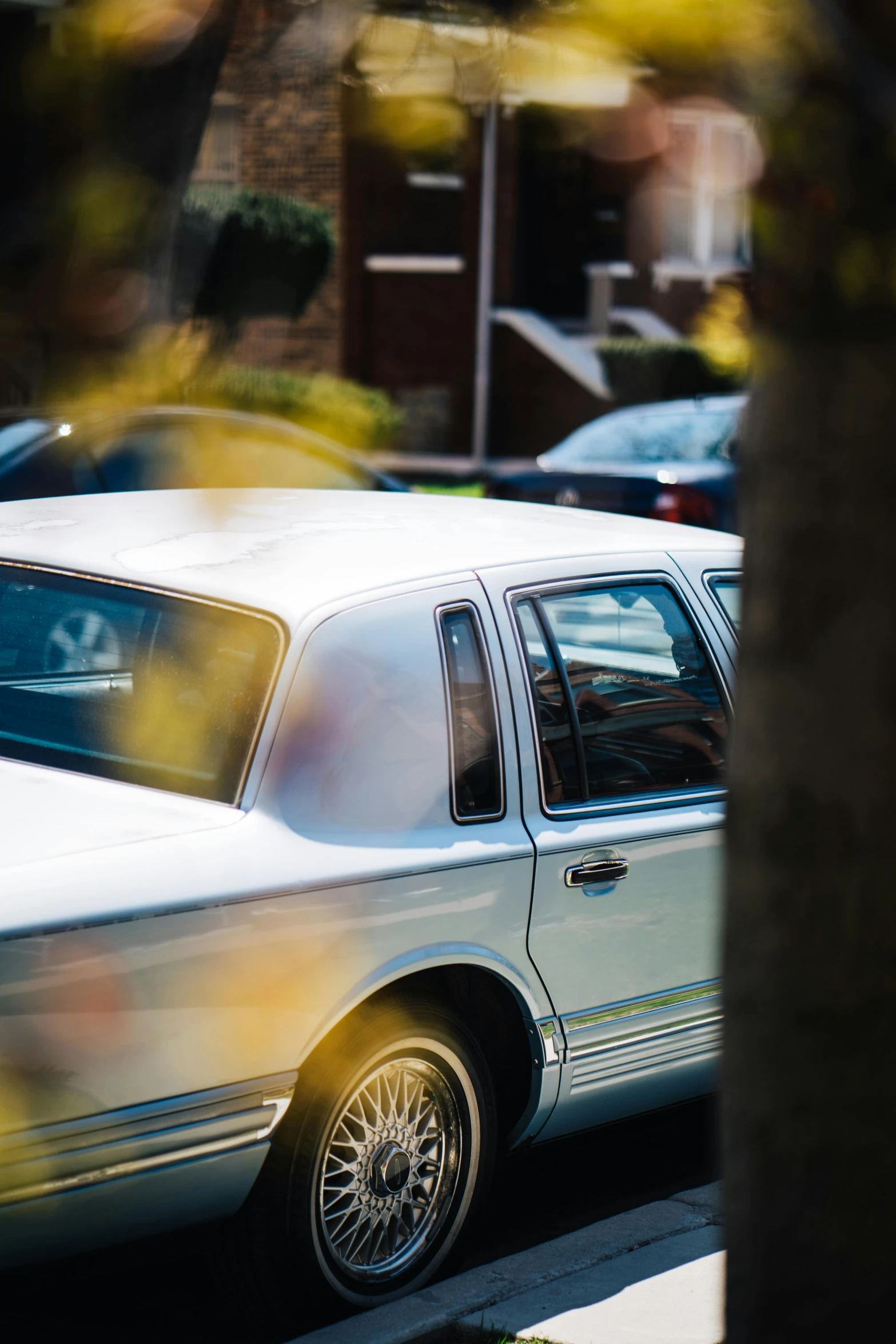 a white car parked on the side of the road, by Michael Goldberg, unsplash, photorealism, walk in a funeral procession, taken in the late 1980s, puttin, lurking