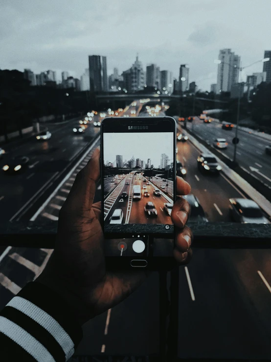 a person taking a picture of a highway, pexels contest winner, realism, city buildings on top of trees, phone wallpaper, looking directly at the camera, picture through the screen