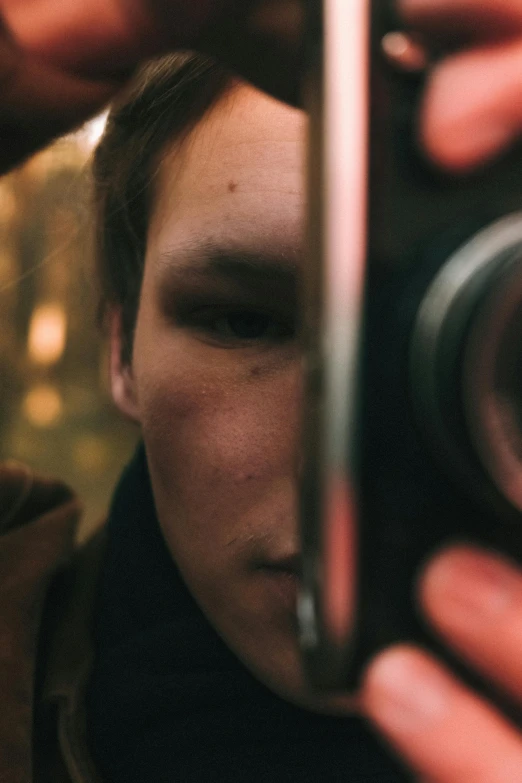 a person taking a picture of themselves in a mirror, by Adam Marczyński, pexels contest winner, realism, super 8 mm, holding a crossbow, teenage boy, imax close-up of face