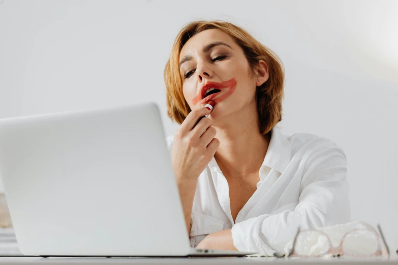 a woman that is sitting in front of a laptop, by Julia Pishtar, trending on pexels, plush lips, on a white table, mouth wired shut, extra crisp image