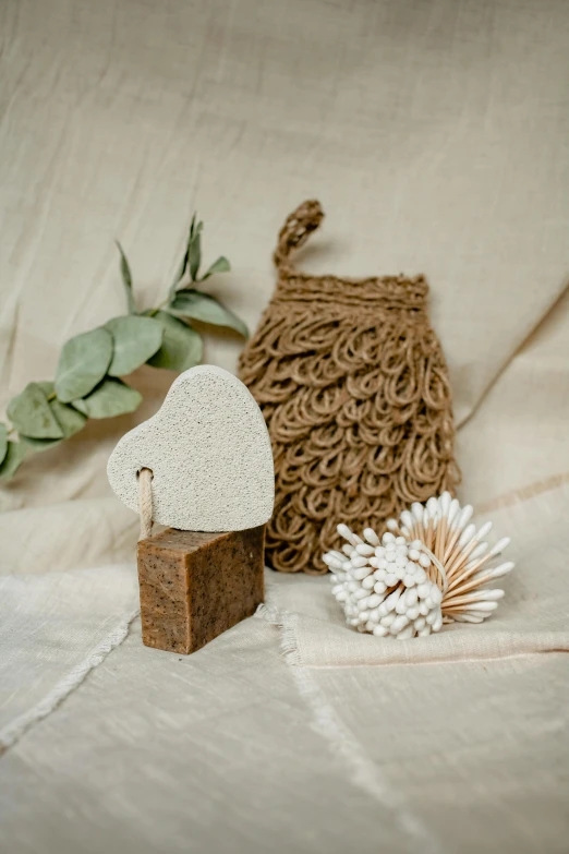 a couple of pieces of wood sitting on top of a bed, a picture, inspired by Eden Box, rose gold heart, sea sponges, detailed product shot, rusticated stone base