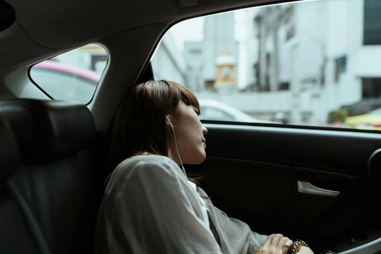 a woman sitting in the passenger seat of a car, an album cover, inspired by Elsa Bleda, pexels contest winner, happening, trending in japan, tired half closed, side profile artwork, ad image