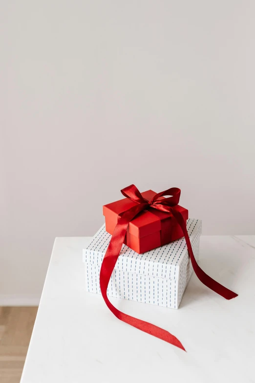 a stack of gift boxes sitting on top of a white table, pexels contest winner, white and red color scheme, two, melbourne, set against a white background