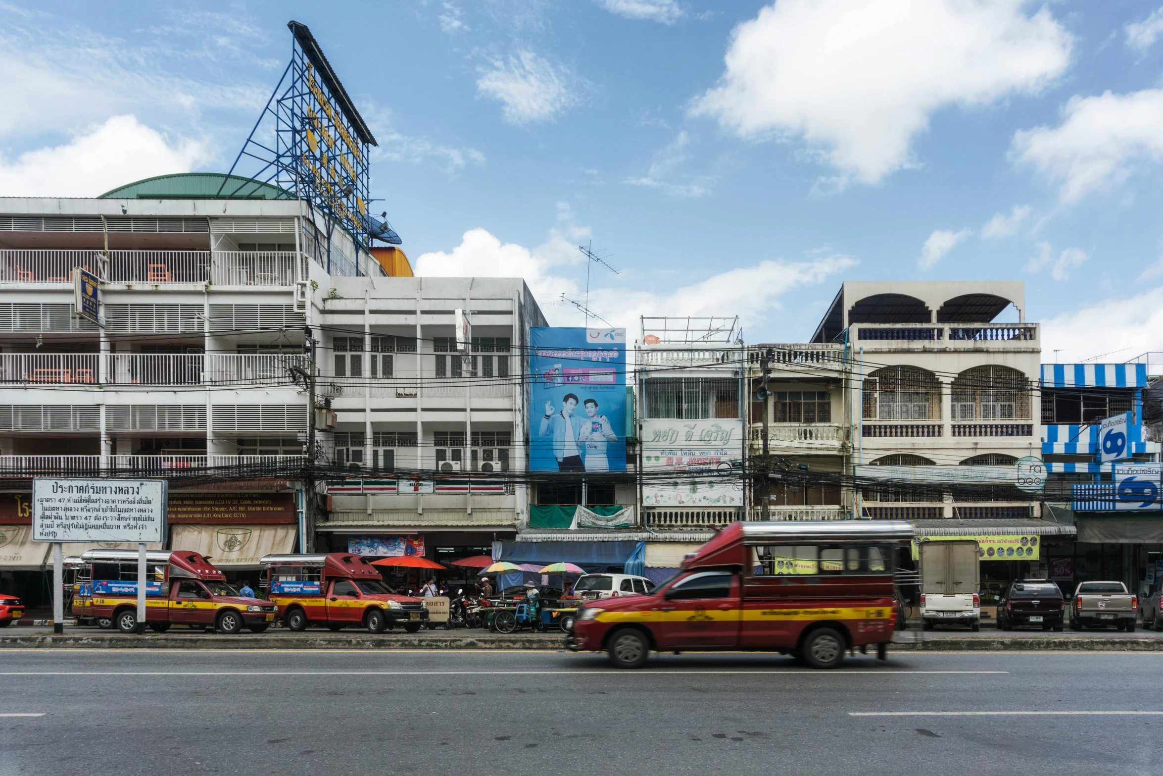 a street filled with lots of traffic next to tall buildings, unsplash, visual art, thai architecture, billboard image, square, old shops